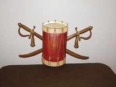 VINTAGE 20″ WIDE 12″ HIGH SEXTON METAL DRUM & SWORDS WALL HANG PLAQUE
