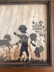 Vintage Milkweed Silhouette In Frame Depicting Children Playing With Dog