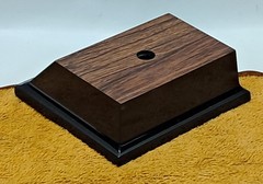 Trophy base, black plastic, woodgrain top, 3 7/6″W x 3 1/8″L x 1 1/4″H, #F.P.35