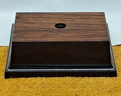 Trophy base, black plastic, woodgrain top, 3 7/6″W x 3 1/8″L x 1 1/4″H, #F.P.35
