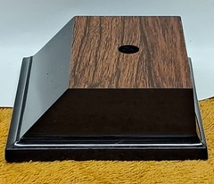 Trophy base, black plastic, woodgrain top, 3 7/6″W x 3 1/8″L x 1 1/4″H, #F.P.35