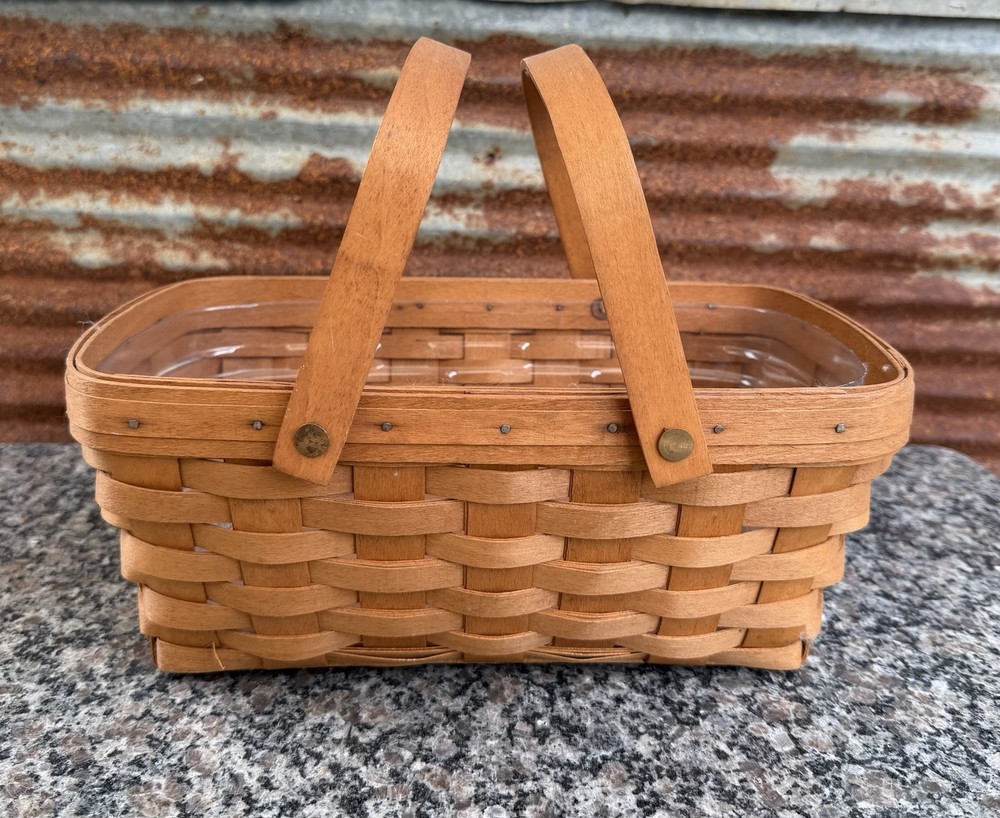 vintage 1993 Longaberger hand-woven handled basket with a clear plastic liner
