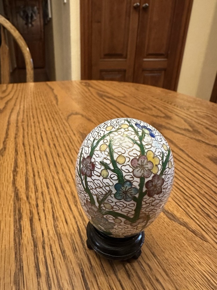white cloisonné enamel egg features a traditional floral pattern